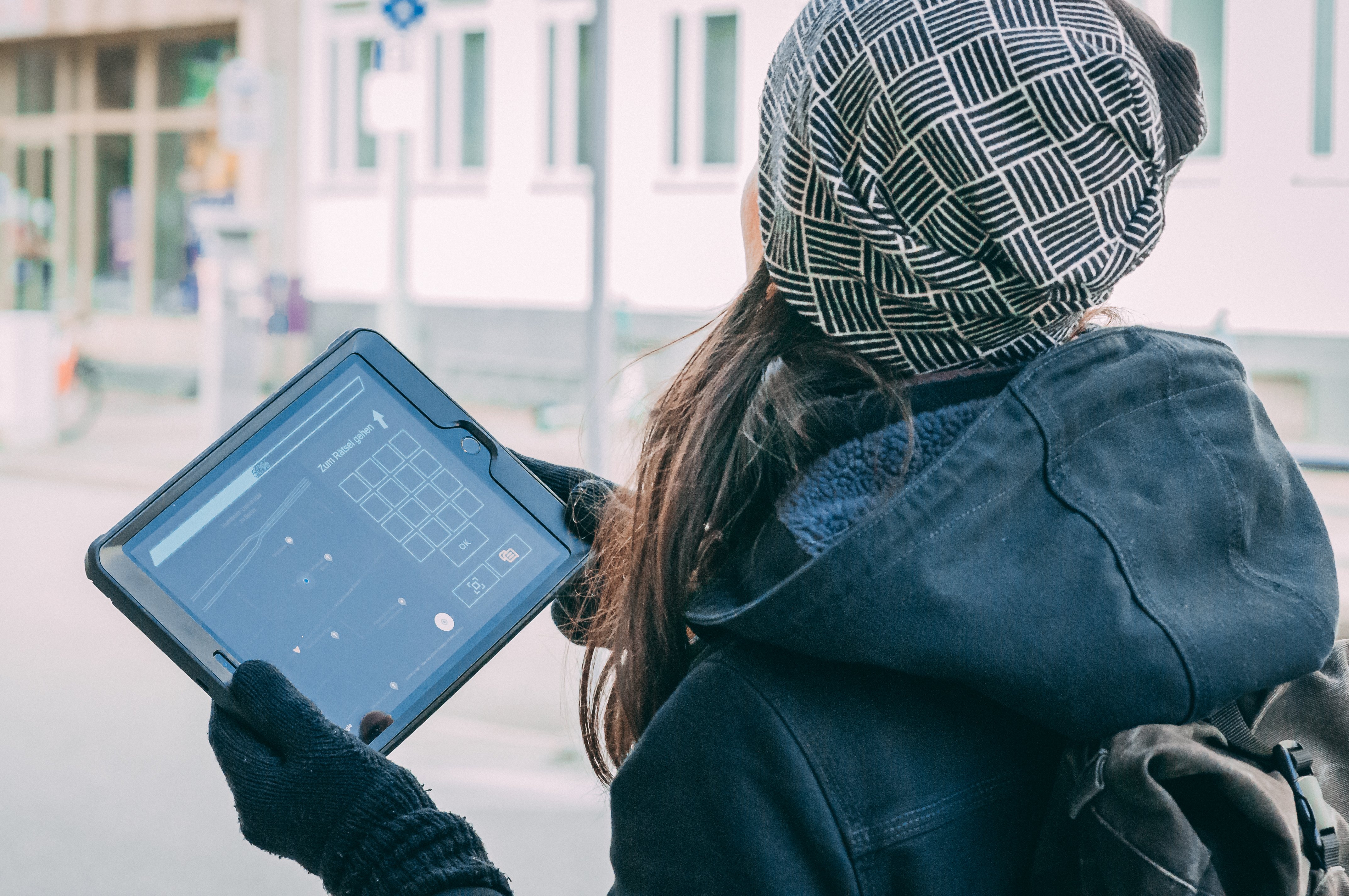 woman with hat holding a tablet